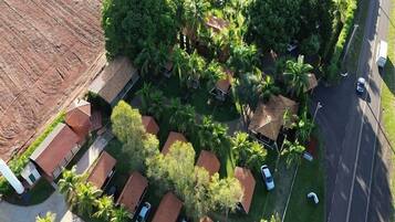 An aerial view of a residential area with multiple houses, a swimming pool, and a road.