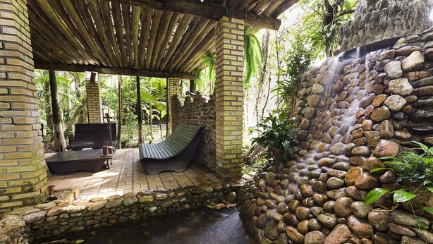 Un espace extérieur abrité, doté d’un mur en pierre et d’une cascade.