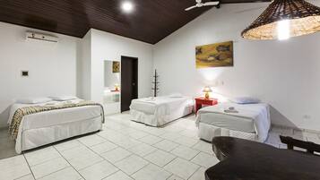 Quarto de hotel com duas camas, teto de madeira, luminária trançada grande e um quadro na parede.