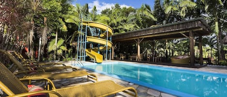 Una piscina al aire libre, sillones reclinables de piscina