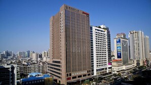 A high-rise hotel with a modern design, featuring multiple floors and a prominent entrance. - Hampton by Hilton Guangzhou Zhujiang New Town (Guangzhou)