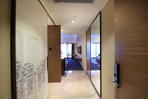 A hotel hallway with a desk, chair, and a large mirror. - Hampton by Hilton Guangzhou Zhujiang New Town (Guangzhou)