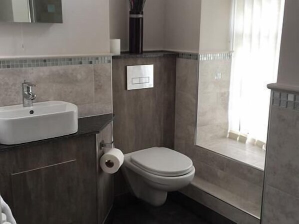 Baño con lavamanos, inodoro y ventana.