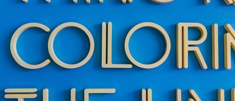 A blue background with white letters spelling "THING N COLORING THE LINE".