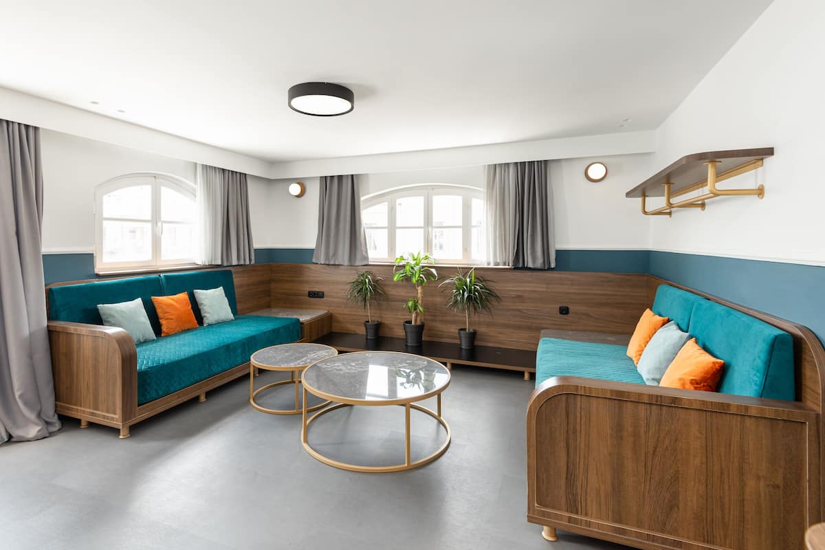 A modern living room with a sofa, coffee table, and potted plants.