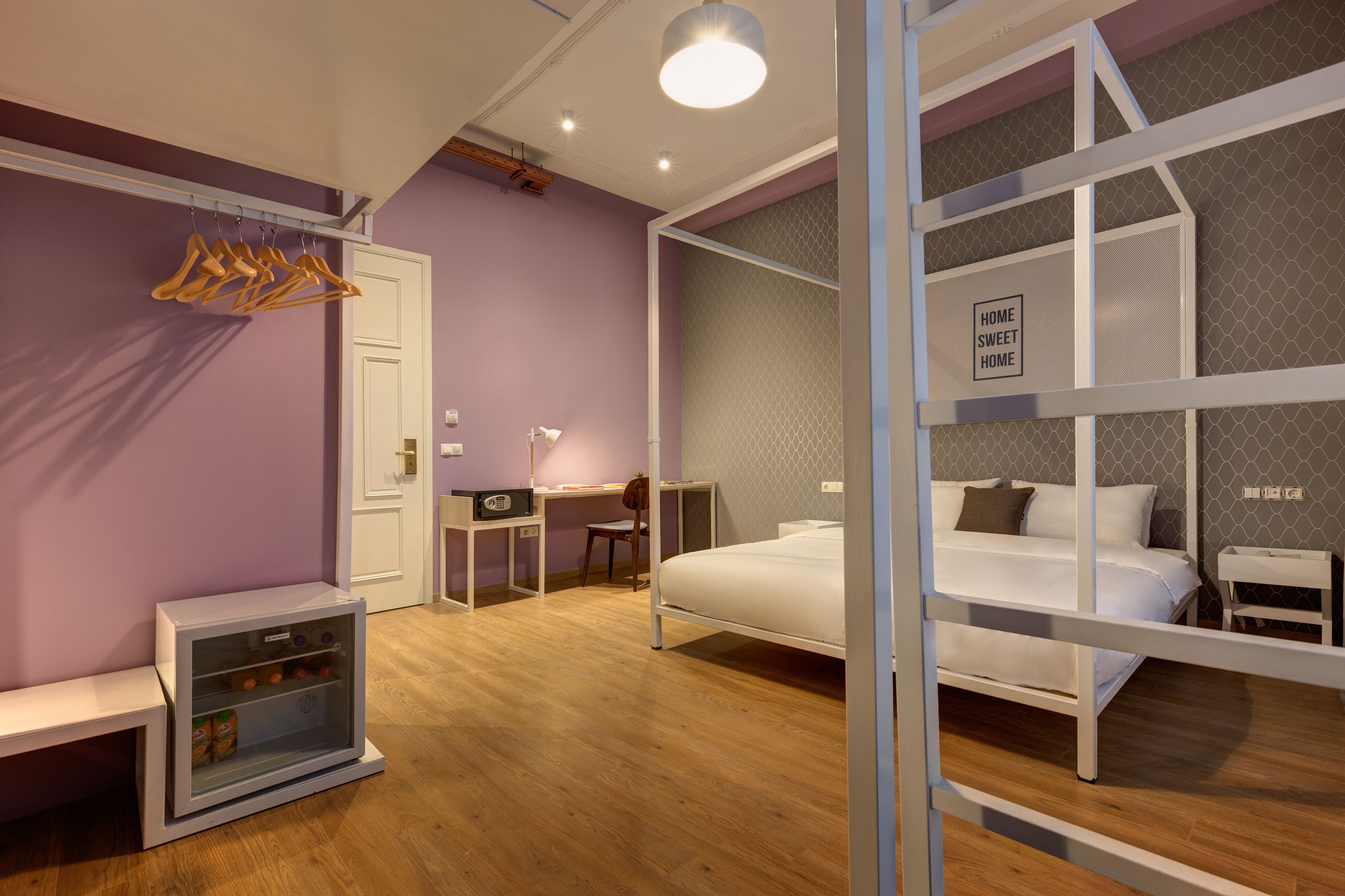 Un dormitorio moderno con cama, mesitas de noche, un escritorio y un armario.