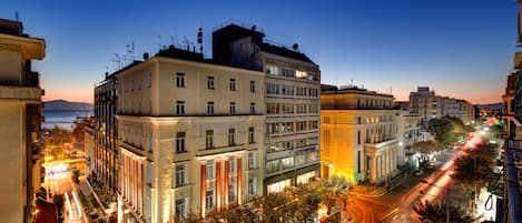 A multi-story building with a classic architectural style, featuring a central courtyard and a view of the street below.