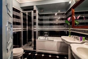 A modern bathroom with a glass-enclosed shower, a freestanding bathtub, and two sinks. - Inn At The Spanish Steps (Rome)
