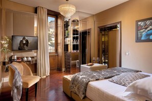 Une chambre dâhĂŽtel Ă©quipĂ©e dâun lit, dâune tĂ©lĂ©vision, dâun bureau, dâune chaise, dâune armoire et offrant une vue sur la ville.