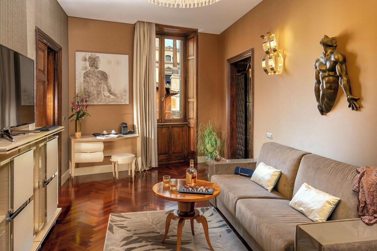 A modern living room with a sofa, coffee table, and a dining area with a view of the city.