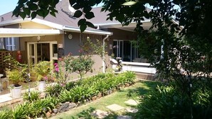 Una propiedad residencial con un jardín bien cuidado, un patio y una entrada visible.