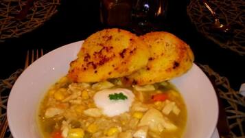 Un tazón de sopa con un huevo poché y una rebanada de pan al lado.