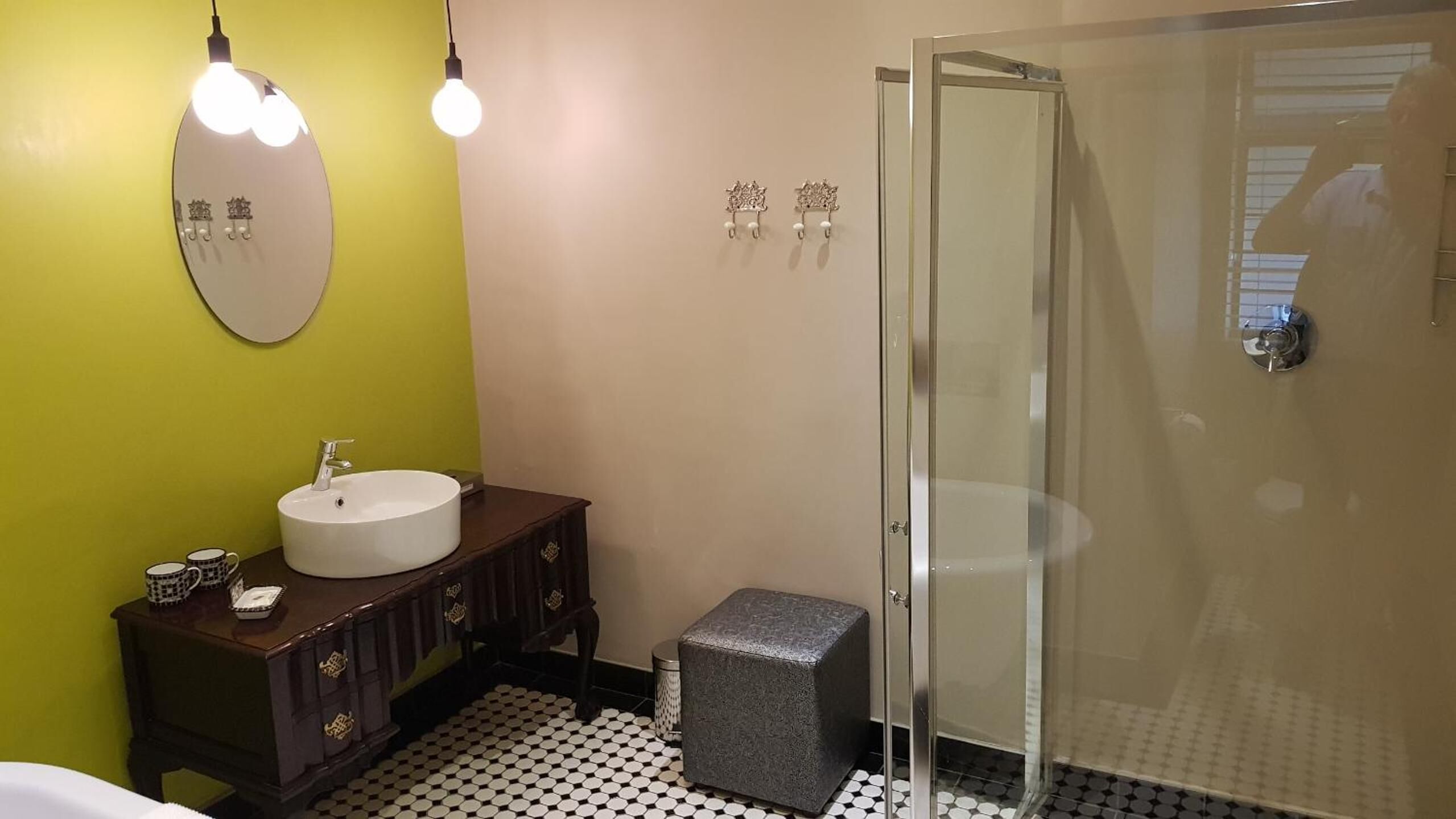 Een badkamer met een rond wastafel, een donker houten wastafelmeubel en een douchecabine van glas.
