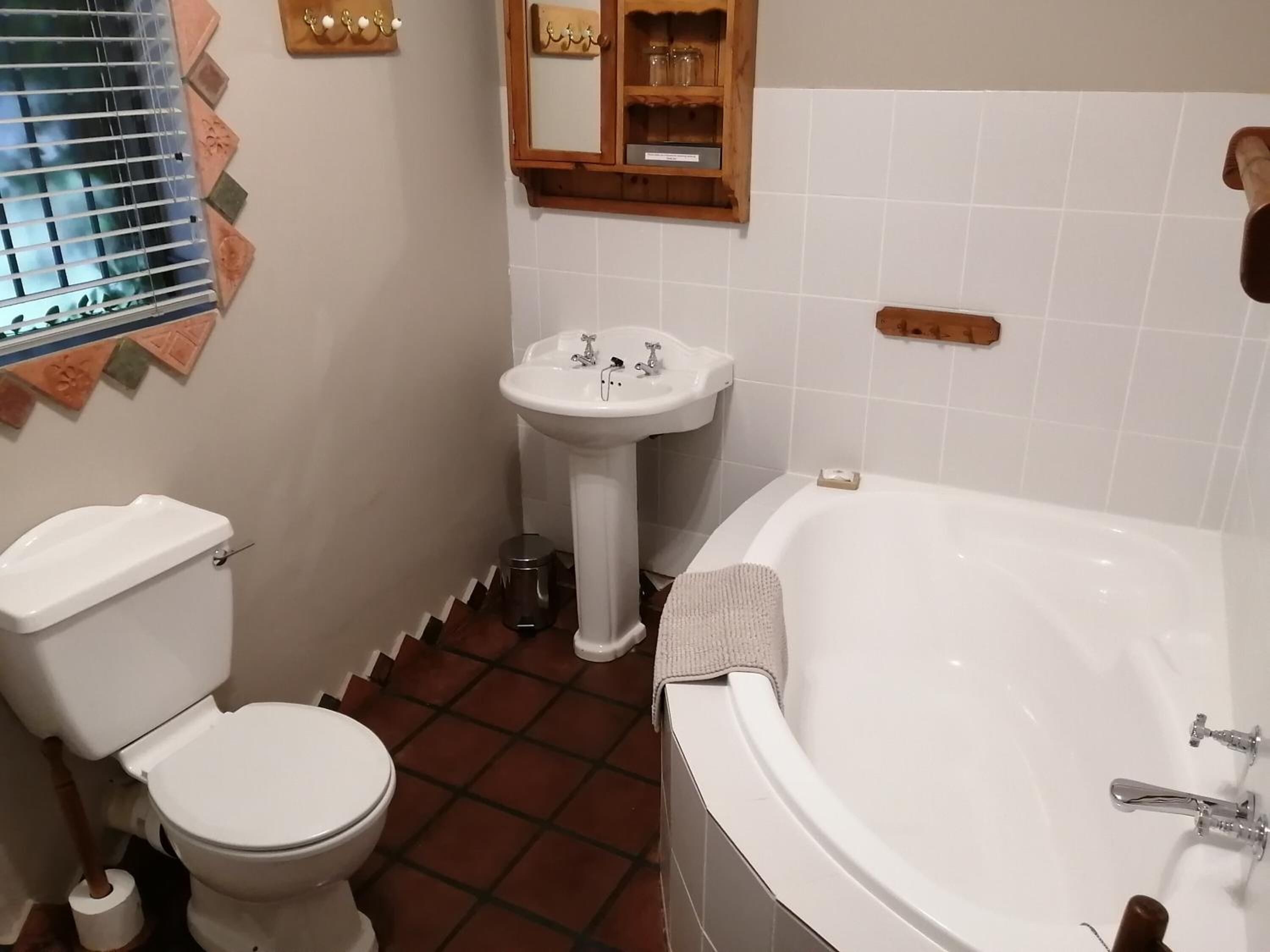 A bathroom with a toilet, sink, and bathtub.