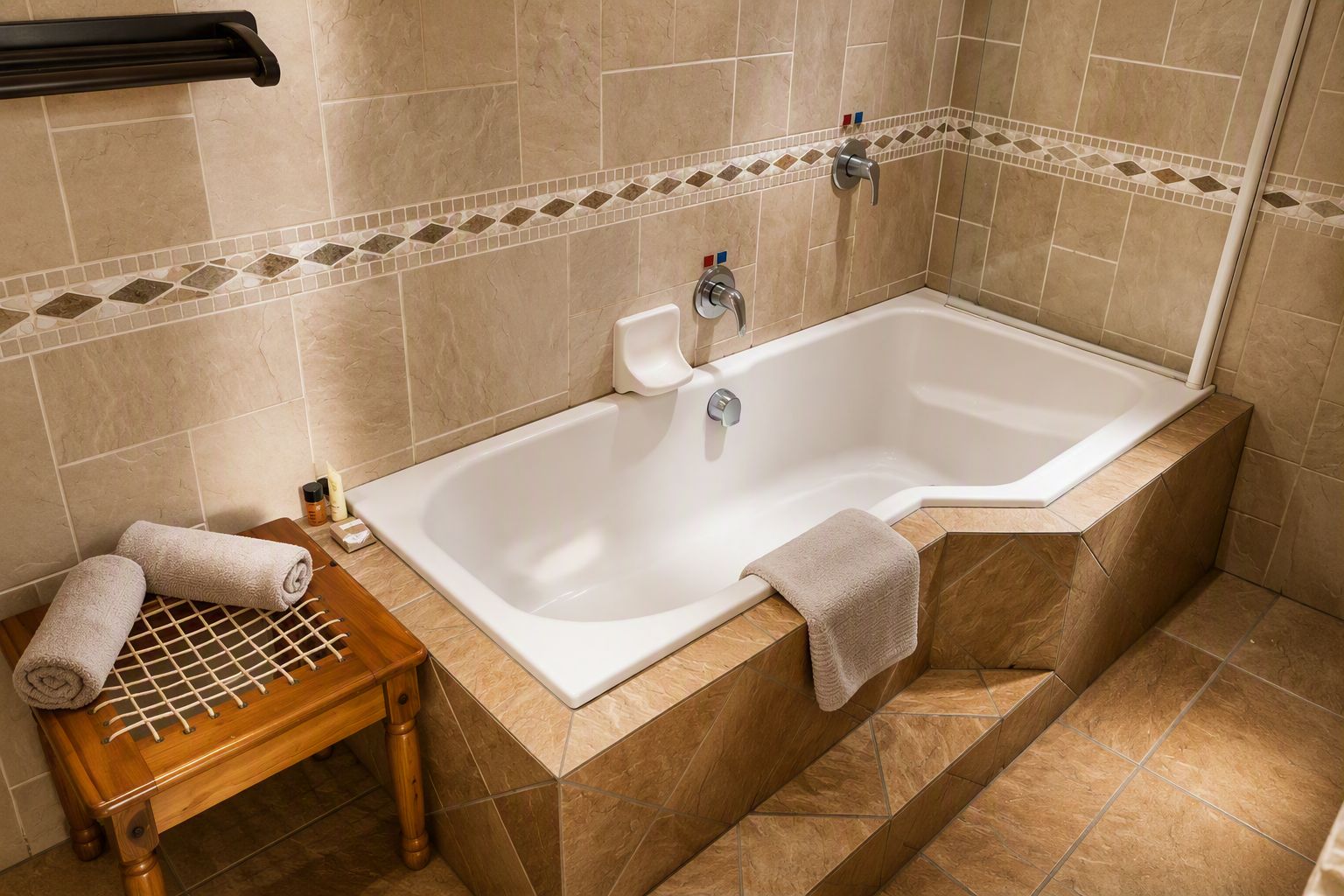 Un bagno con una vasca, una panca in legno e un portascopevoli.