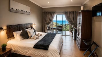 A bedroom with a bed, a nightstand, a TV, and a view of the ocean through a balcony.