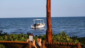 A boat on calm water, viewed from a distance. - Kijongo Bay Beach Resort (Pangani)