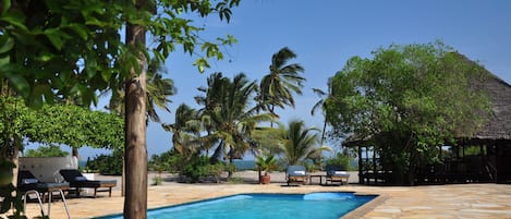 Una piscina al aire libre, sillones reclinables de piscina