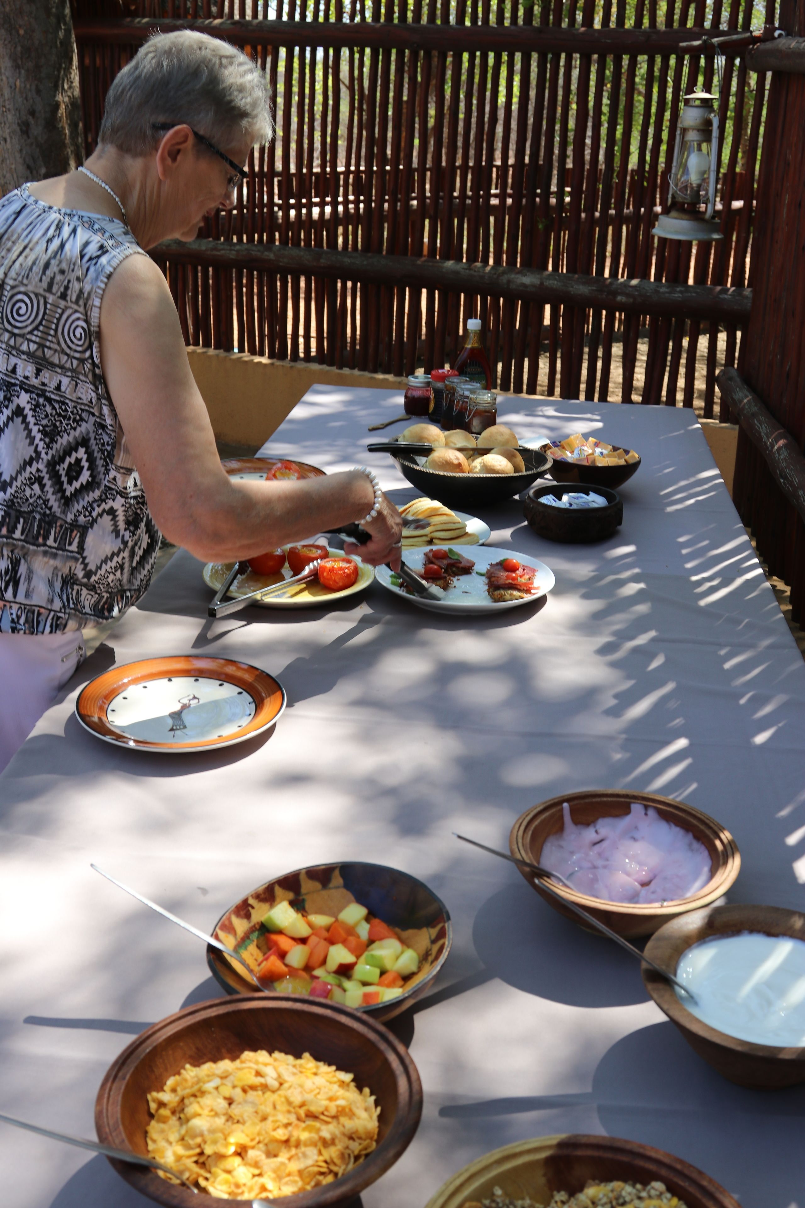A dining table with various dishes and a person serving food.