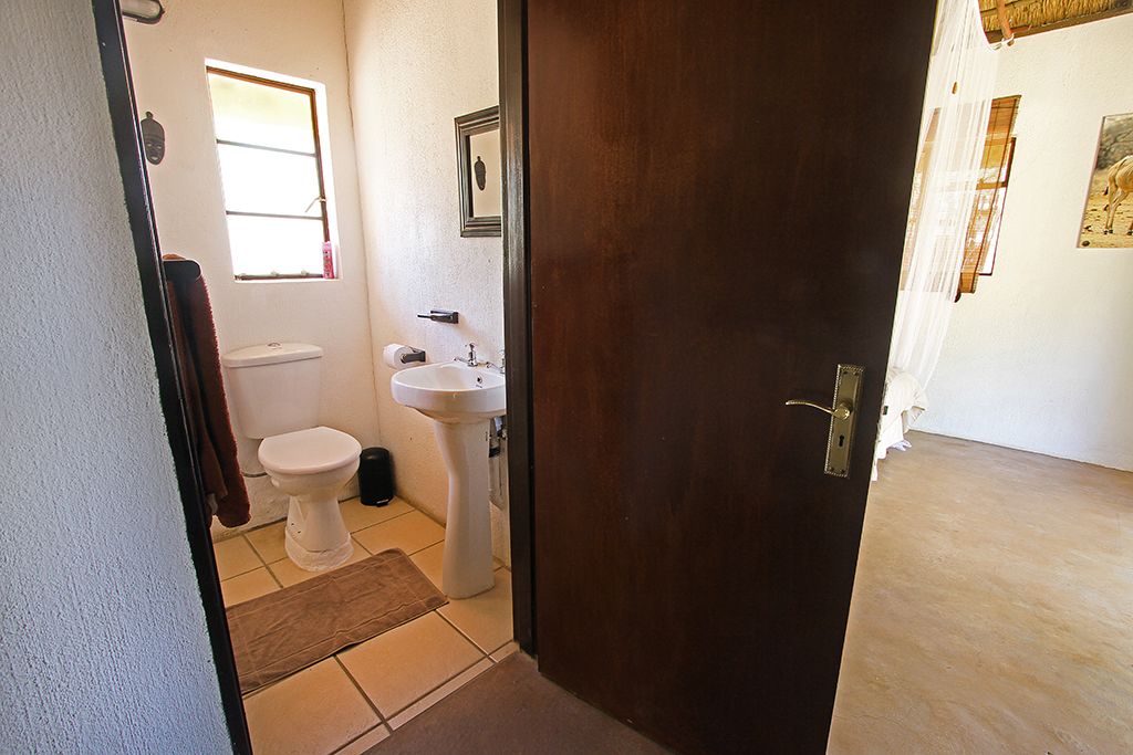 Un baño con inodoro, lavamanos y ventana.