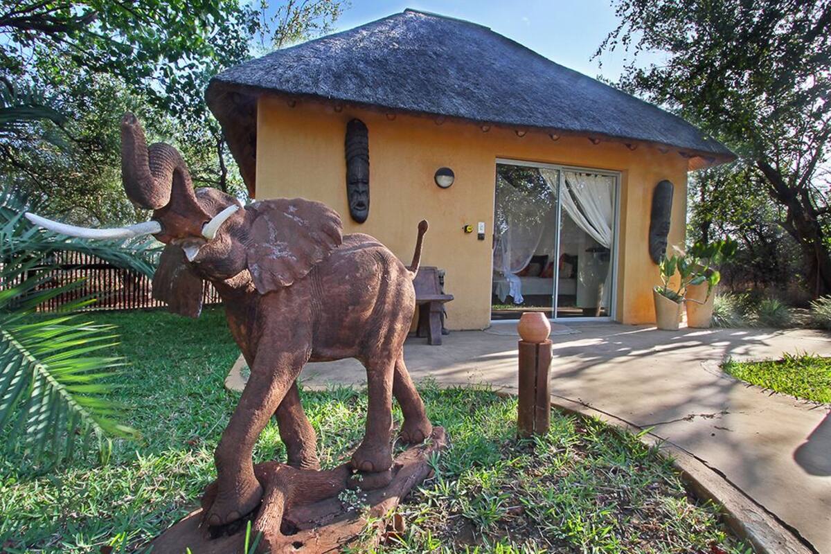 Un edificio con techo de paja y una estatua de un elefante en su fachada.