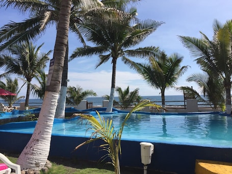 Una piscina al aire libre, sillones reclinables de piscina