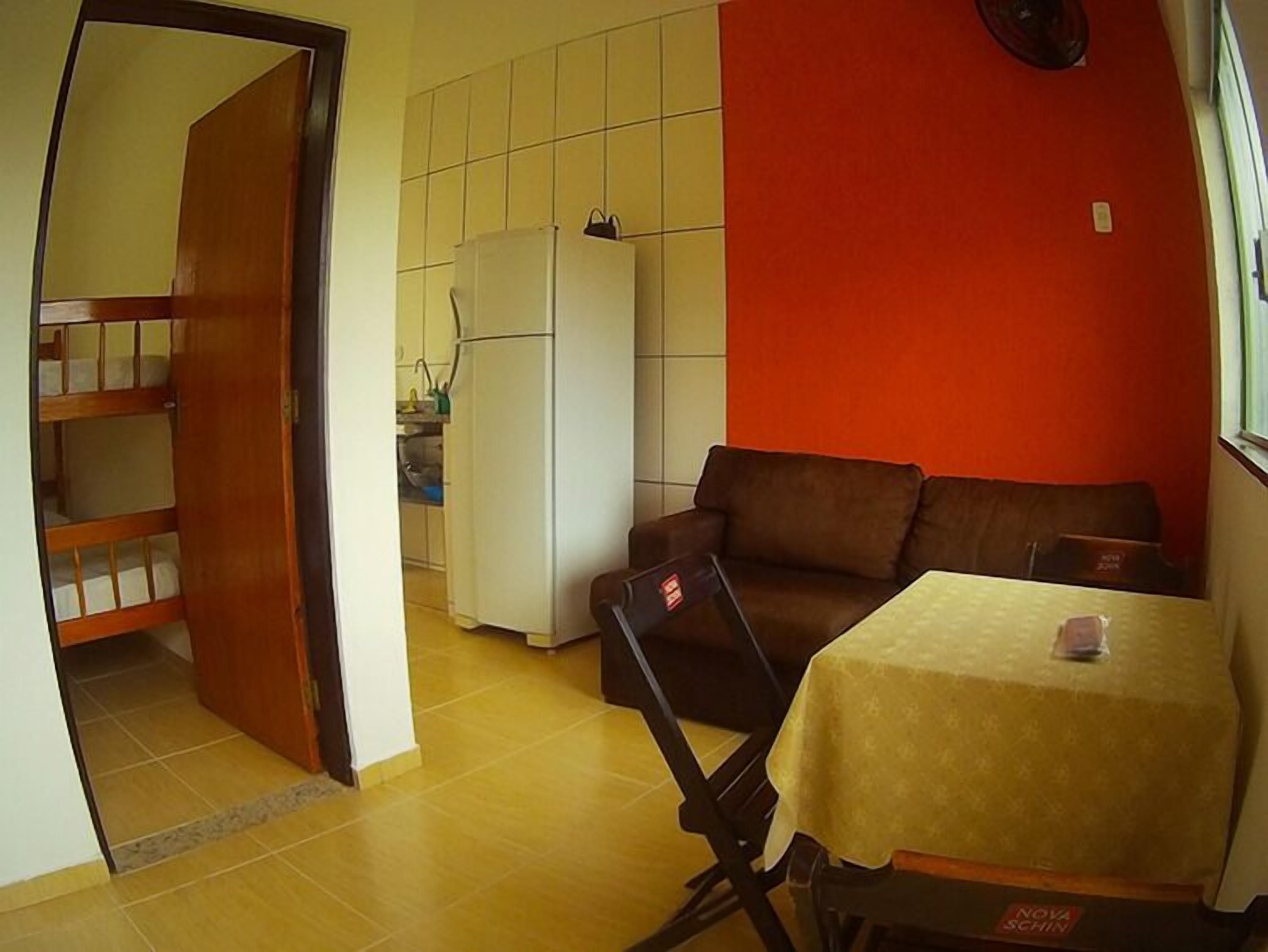 A compact living space with a kitchenette, a sofa, and a small dining table.