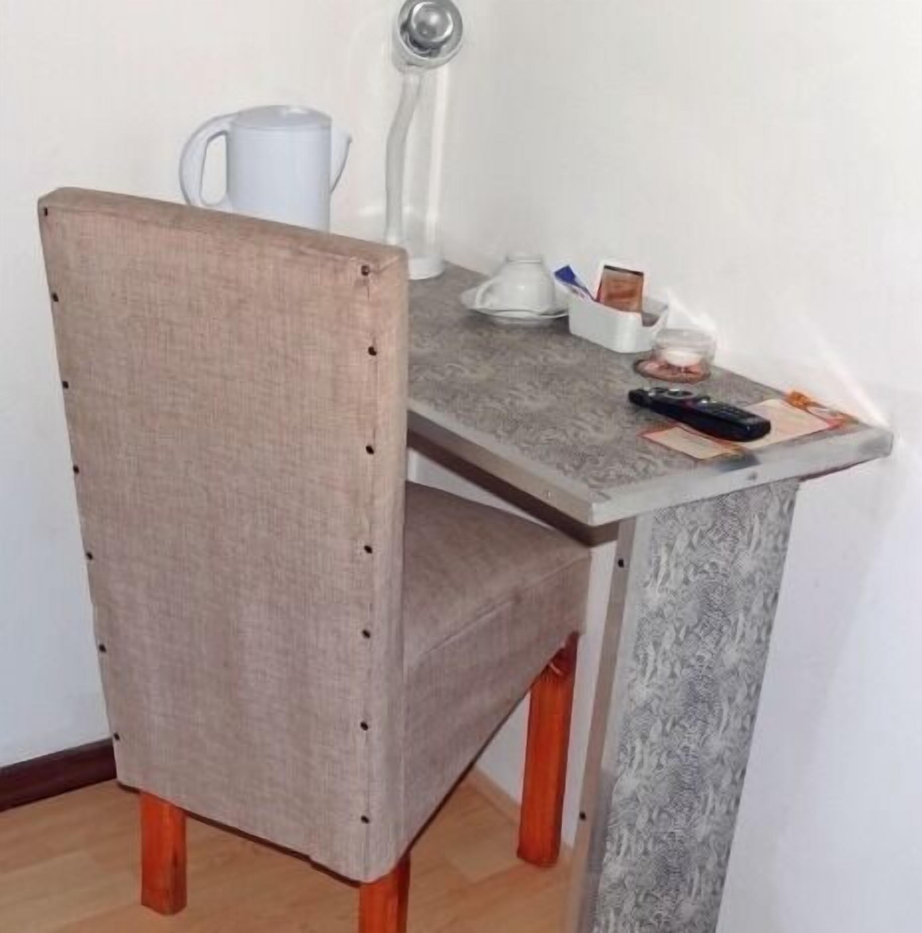Un petit coin repas comprenant une chaise, une table et une machine à café.