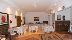 A hotel lobby with multiple tables and chairs, a reception desk, and a fireplace. - Aligeo Guest House (Senqu)