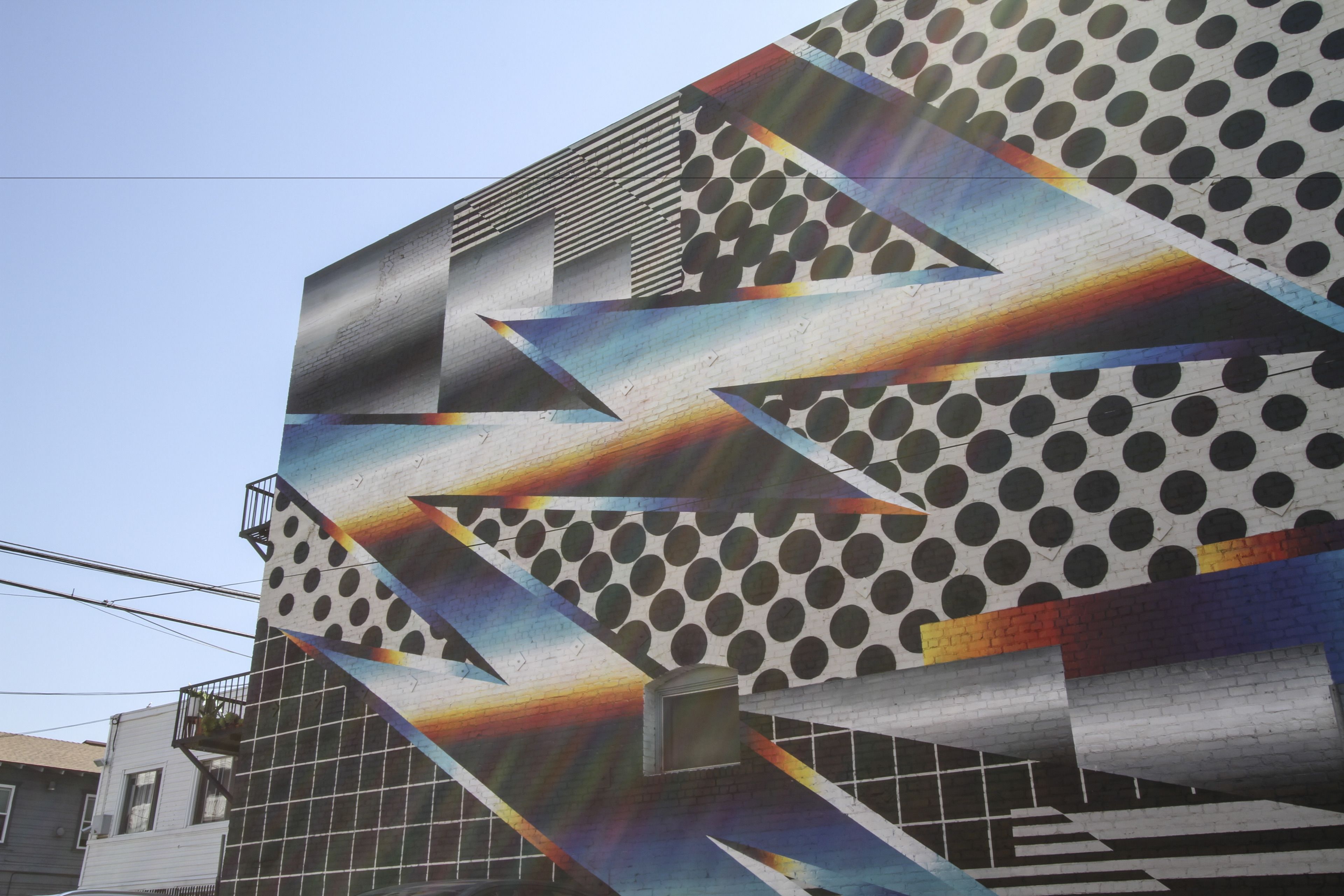 Fachada de edificio con un diseño geométrico y una escalera.