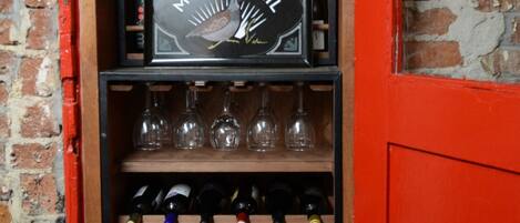 A wine rack with multiple bottles and a framed sign.