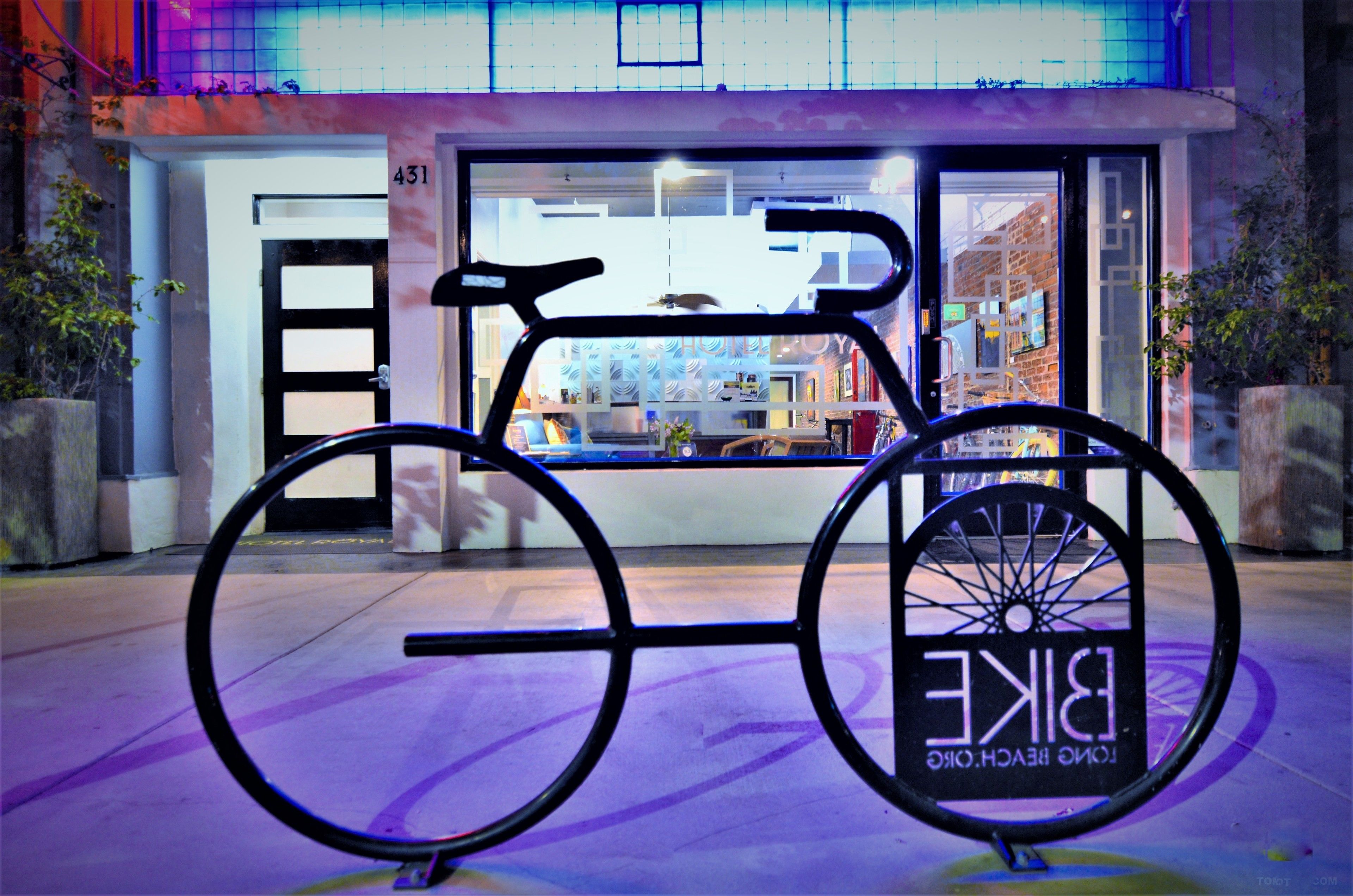 Una bicicleta con un letrero que dice "BIRKE" frente a un edificio con puerta de vidrio y el número 431.
