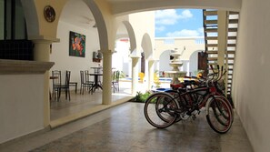 A hotel corridor with a dining area, a fountain, and bicycles.