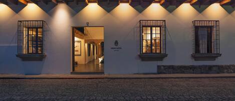 A building with a tiled roof, a sign reading "Good Hotel," and a cobblestone ground.