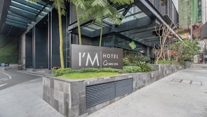 A modern hotel entrance with a sign reading "I'M HOTEL Onsen Spa". - I’M Hotel (Makati)