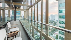 A modern interior with a balcony overlooking a cityscape. - I’M Hotel (Makati)