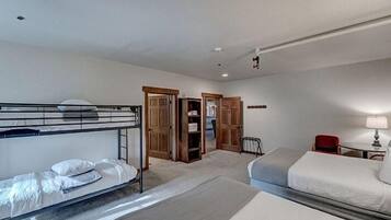 A hotel room with bunk beds, a desk, a chair, and a wardrobe.