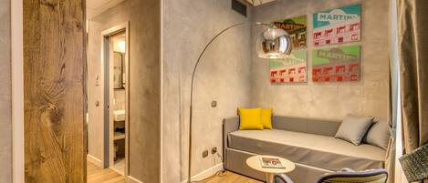 A modern room with a sofa, a chair, a table, and a floor lamp.