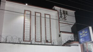 A building with barred windows and a sign for Hotel Royal Palace. - Hotel Royal Palace (Karachi)
