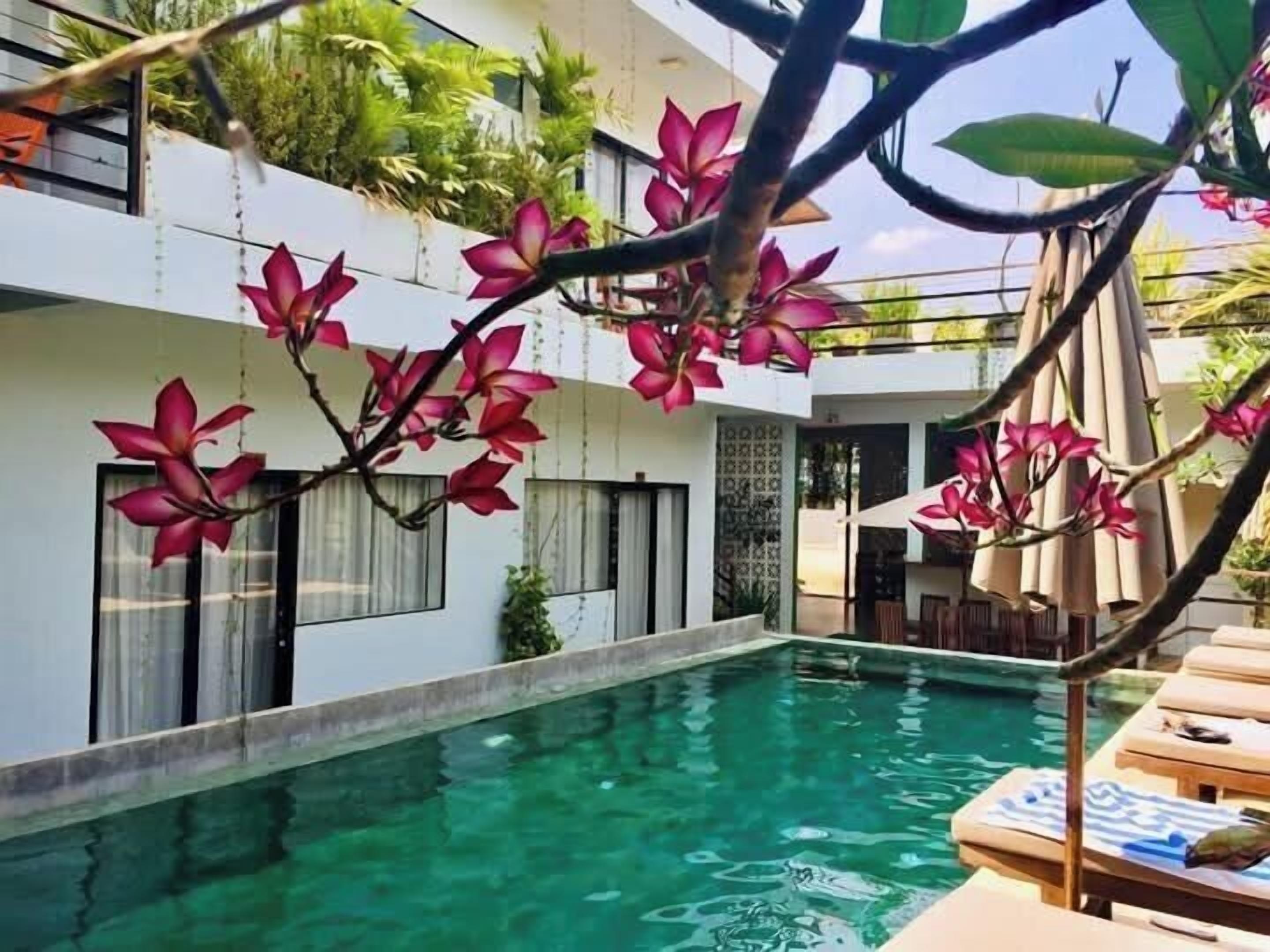 Una piscina al aire libre, sillones reclinables de piscina