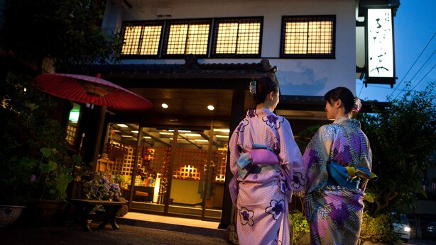 Un edificio japonés tradicional con tejado de tejas y ventanas amplias.