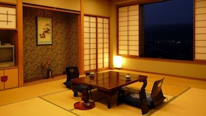 Una habitación japonesa tradicional con suelo de tatami, una mesa baja y paneles shoji.