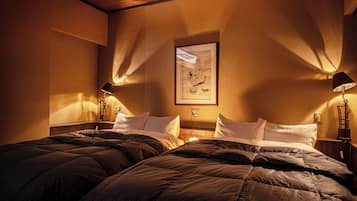 Una habitación de hotel con dos camas, una obra de arte enmarcada en la pared y dos lámparas de noche.