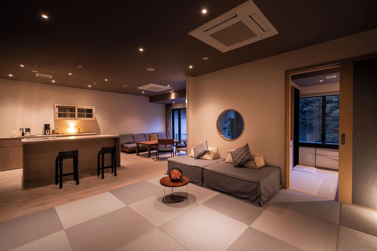 Un salon moderne comprenant un canapé, une table basse et un coin repas avec des chaises.