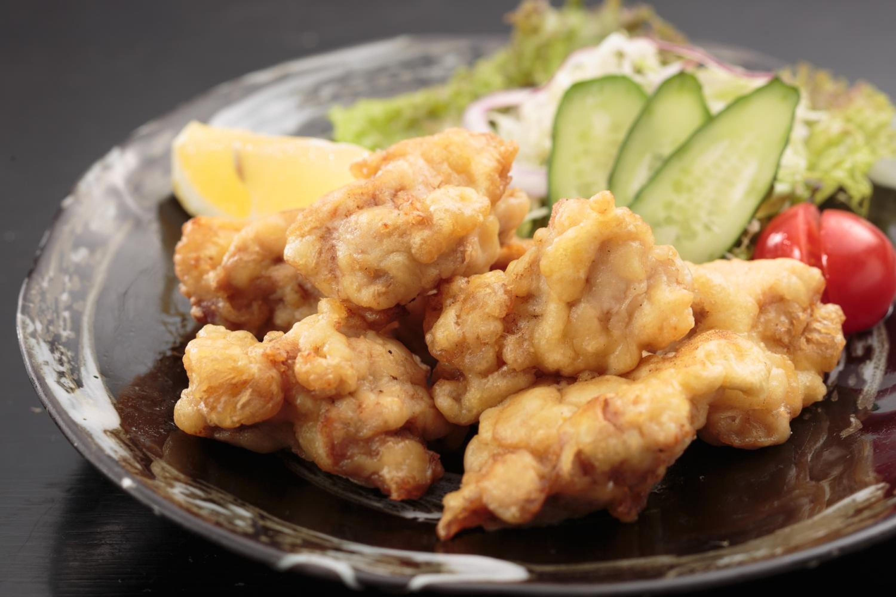 A plate of fried food with a side salad.