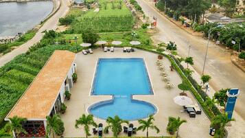 Una piscina al aire libre, sillones reclinables de piscina