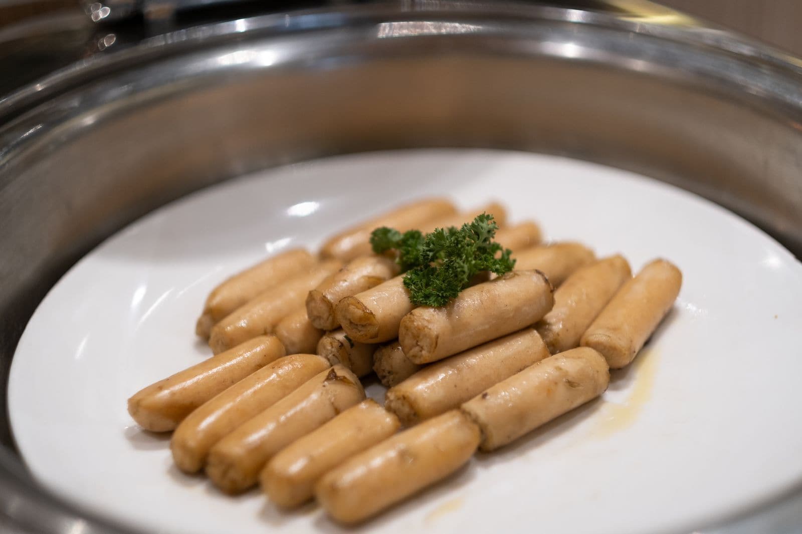 Un plato de salchichas con guarnición de perejil.