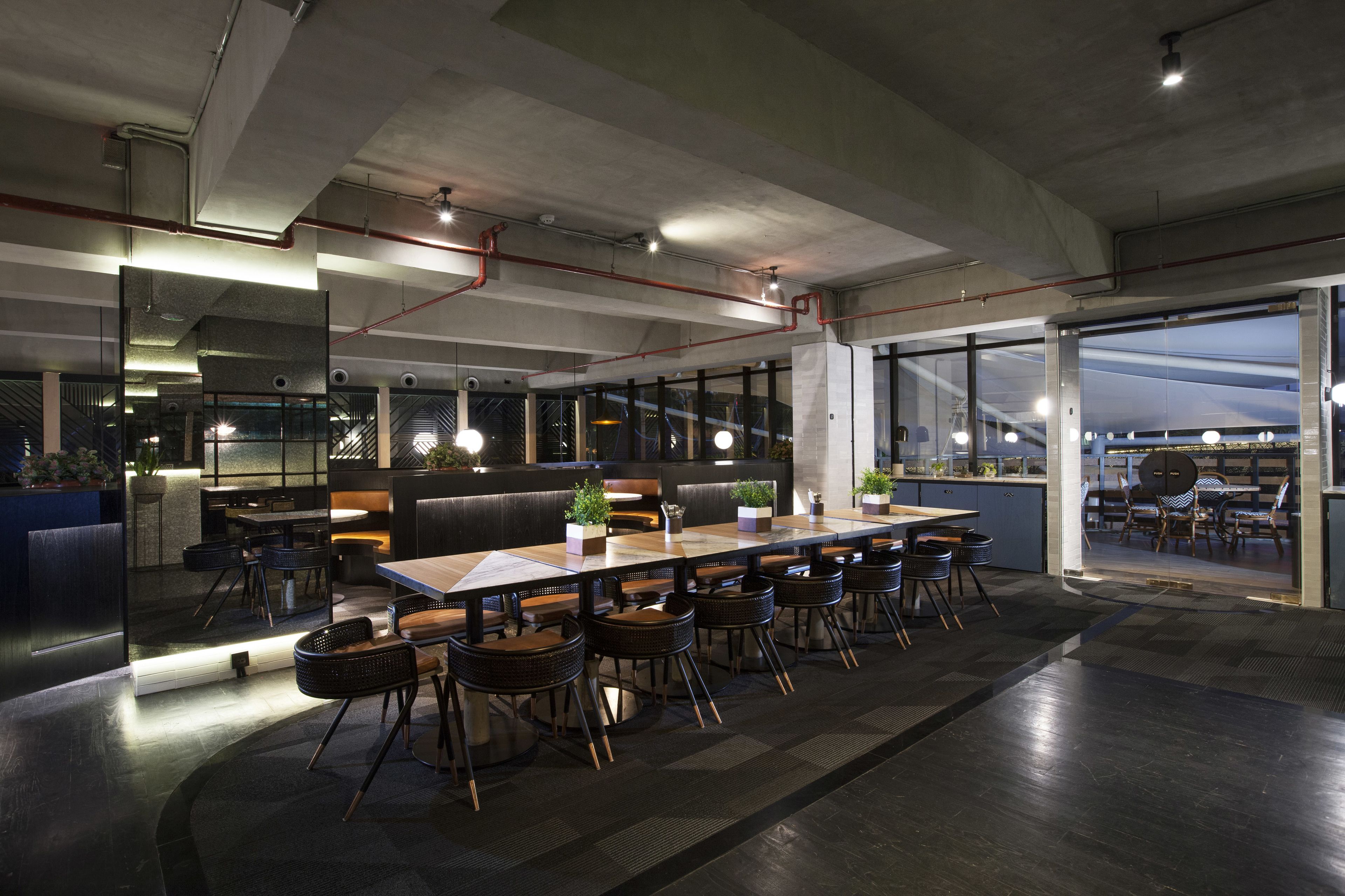 A modern conference room with a long table, multiple chairs, and a glass partition.