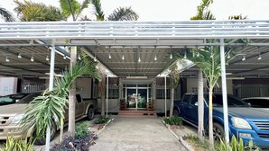 A covered car wash facility with multiple cars parked under a metal roof, surrounded by potted plants. - Ban Ton Resort (Udon Thani)