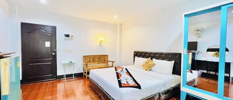 A hotel room with a bed, a bedside table, a mirror, and a wardrobe.